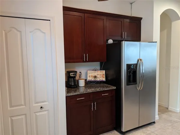 a kitchen with granite countertop cabinets and refrigerator