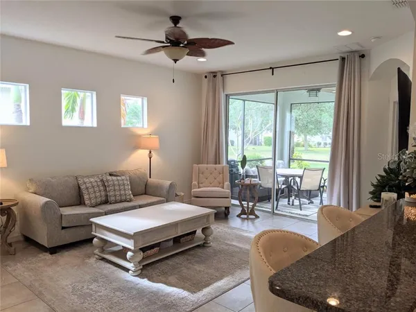 a living room with furniture a large window and a flat screen tv