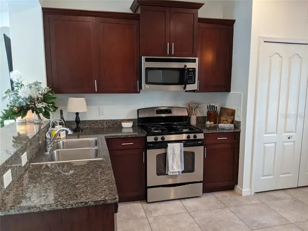 a kitchen with stainless steel appliances granite countertop a stove a microwave and a refrigerator