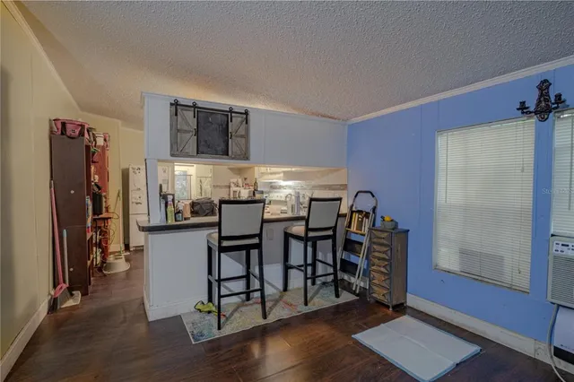 a kitchen with stainless steel appliances a dining table chairs and a refrigerator
