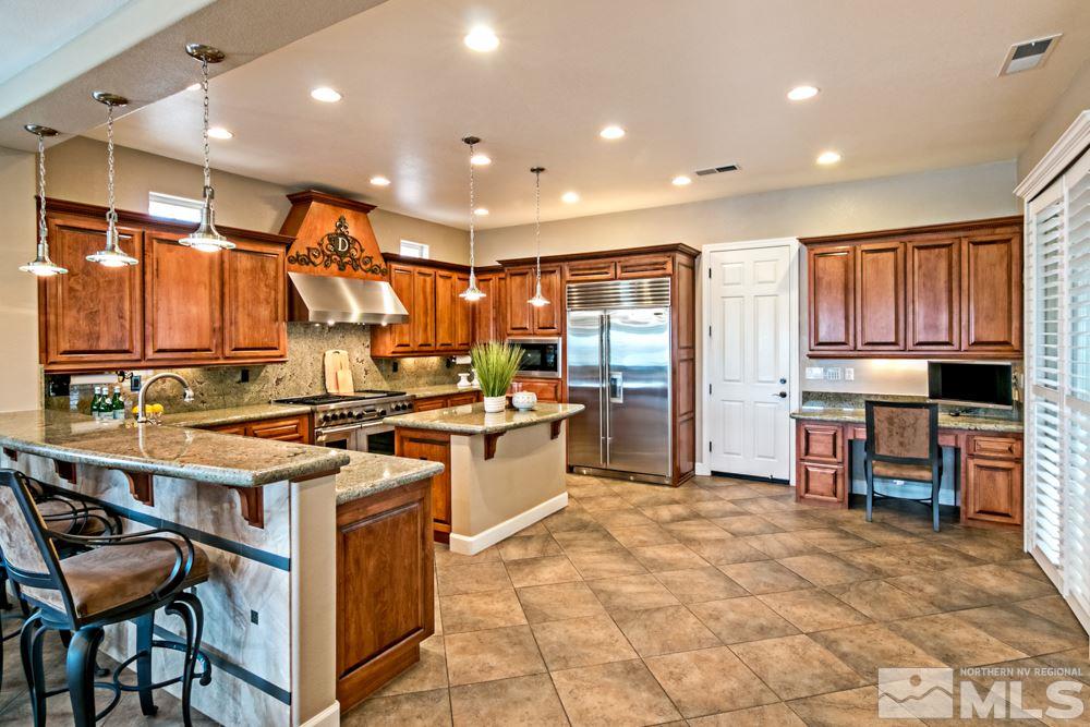 10125 Burghley Lane Reno, NV 89521 - Photo 6 of 13 a kitchen with stainless steel appliances granite countertop a stove top oven a sink dishwasher and a refrigerator