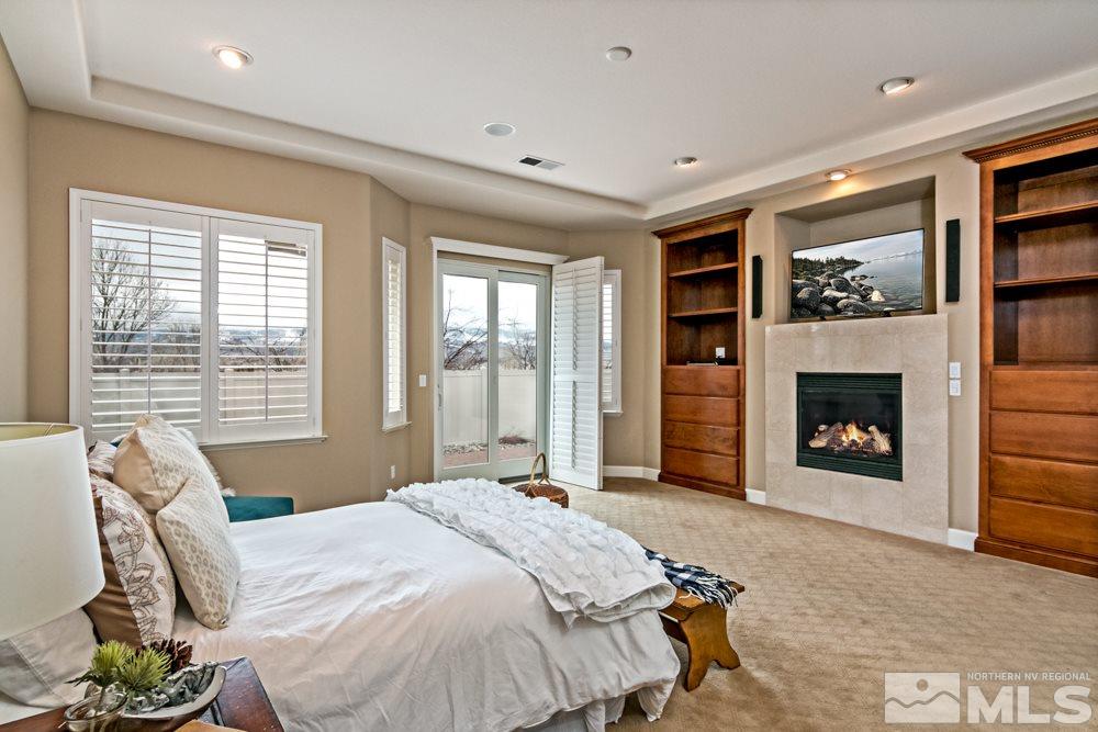 10125 Burghley Lane Reno, NV 89521 - Photo 9 of 13 a spacious bedroom with a bed and a fireplace
