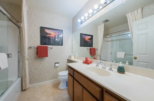 a bathroom with a sink and a mirror with toilet