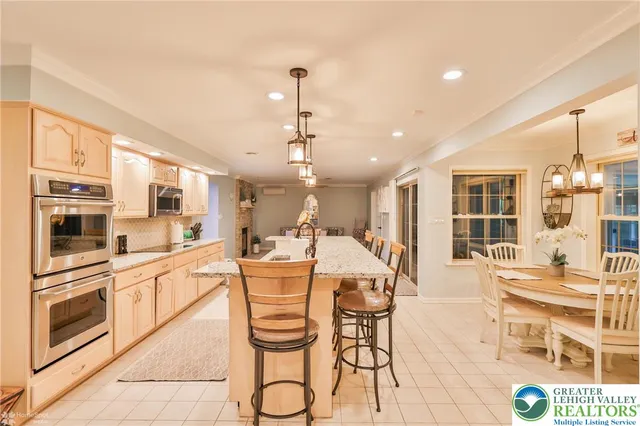 a large white kitchen with a large window and stainless steel appliances