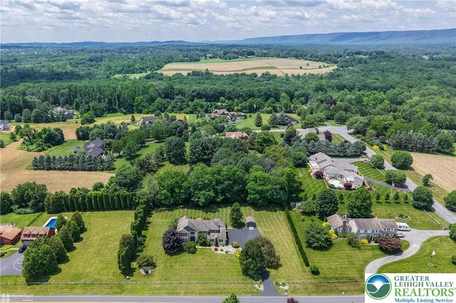 an aerial view of residential houses with outdoor space and swimming pool