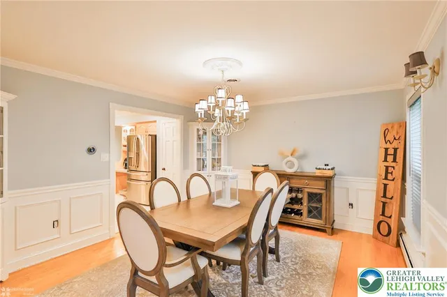 a view of a dining room with furniture a chandelier and wooden floor