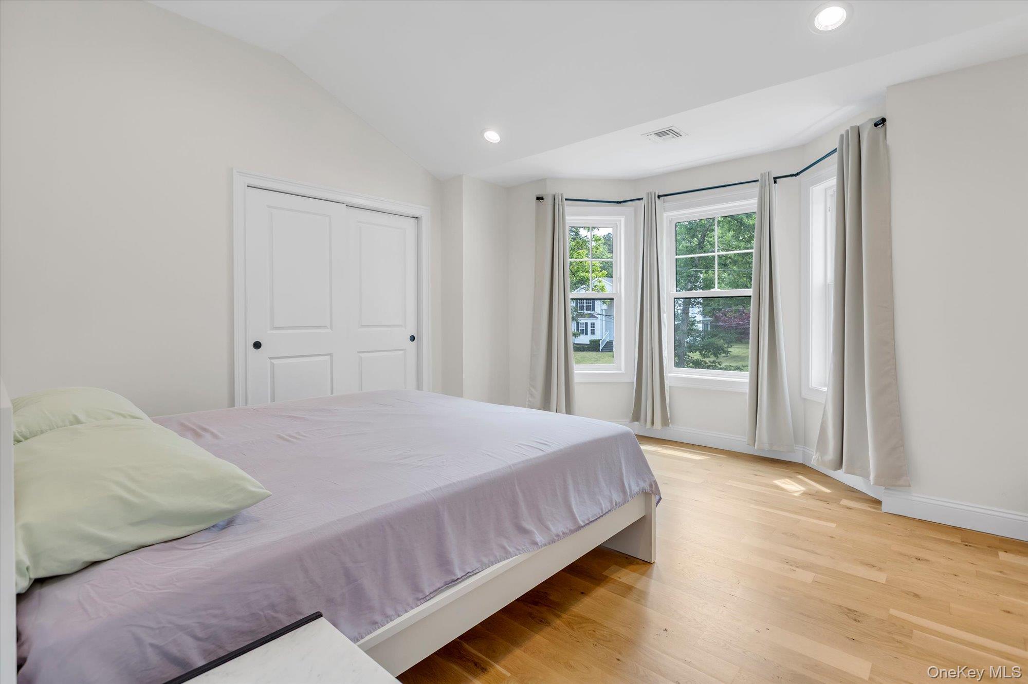 135 Elizabeth Way Ridge, NY 11961 - Photo 13 of 24 a bedroom with a bed and a window