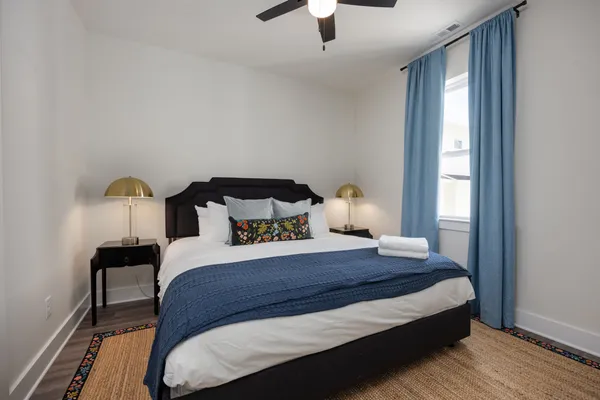 a bedroom with a bed and wooden floor