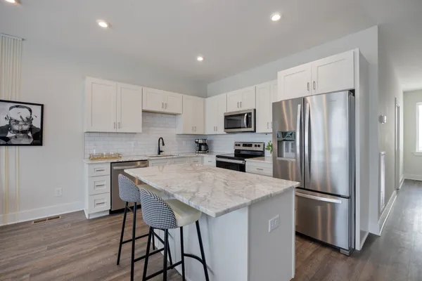a kitchen with a refrigerator a sink and a stove top oven