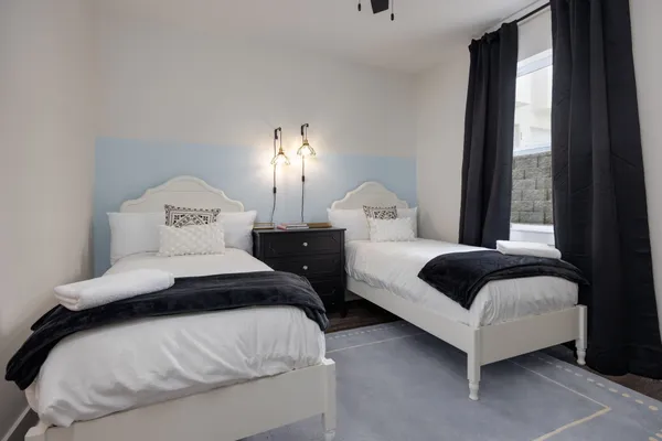 a bedroom with two beds and large window