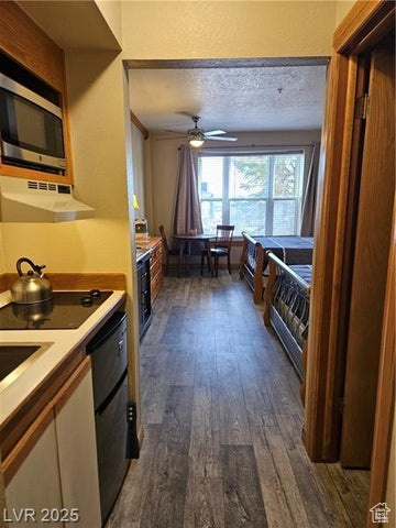 223 Hunter Ridge Drive, Unit E121 Brian Head, UT 84719 - Photo 3 of 35 Kitchen with exhaust hood, stainless steel microwave, dark wood-type flooring, ceiling fan, and light countertops