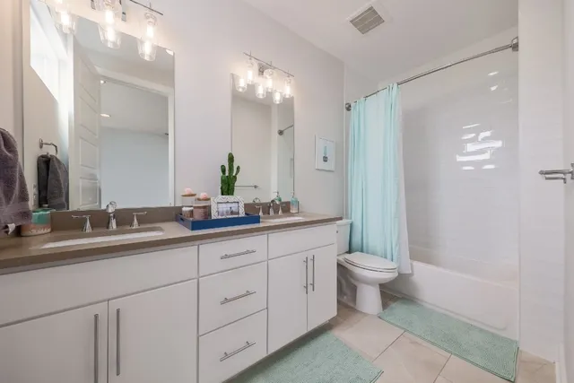 a bathroom with a double vanity sink and a mirror
