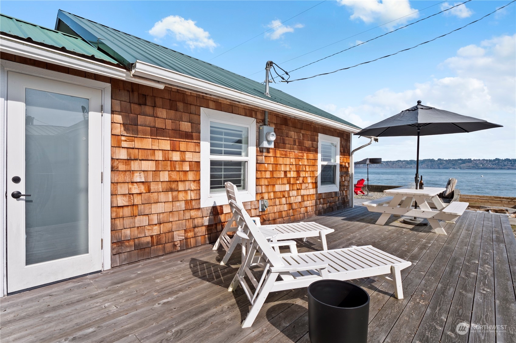 8003 Possession Beach Walk Clinton, WA 98236 - Photo 5 of 31 a view of a patio with table and chairs under an umbrella