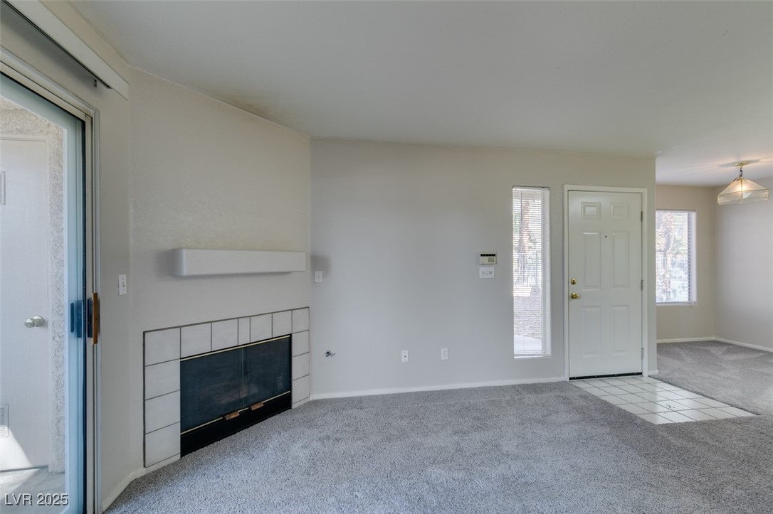 5211 Caspian Springs Drive, Unit 101 Las Vegas, NV 89120 - Photo 13 of 37 Unfurnished living room with light carpet and a tile fireplace