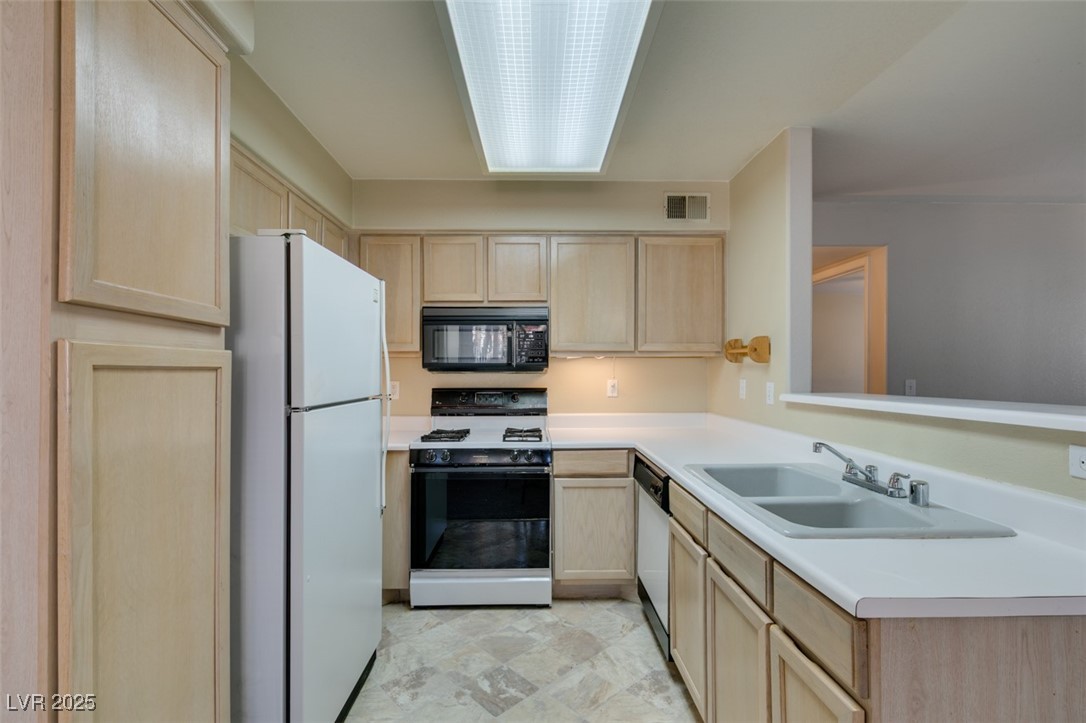 5211 Caspian Springs Drive, Unit 101 Las Vegas, NV 89120 - Photo 26 of 37 Kitchen featuring light brown cabinetry, white appliances, and light countertops