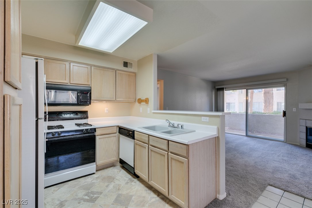 5211 Caspian Springs Drive, Unit 101 Las Vegas, NV 89120 - Photo 37 of 37 Kitchen with light brown cabinets, open floor plan, light countertops, white appliances, and light carpet