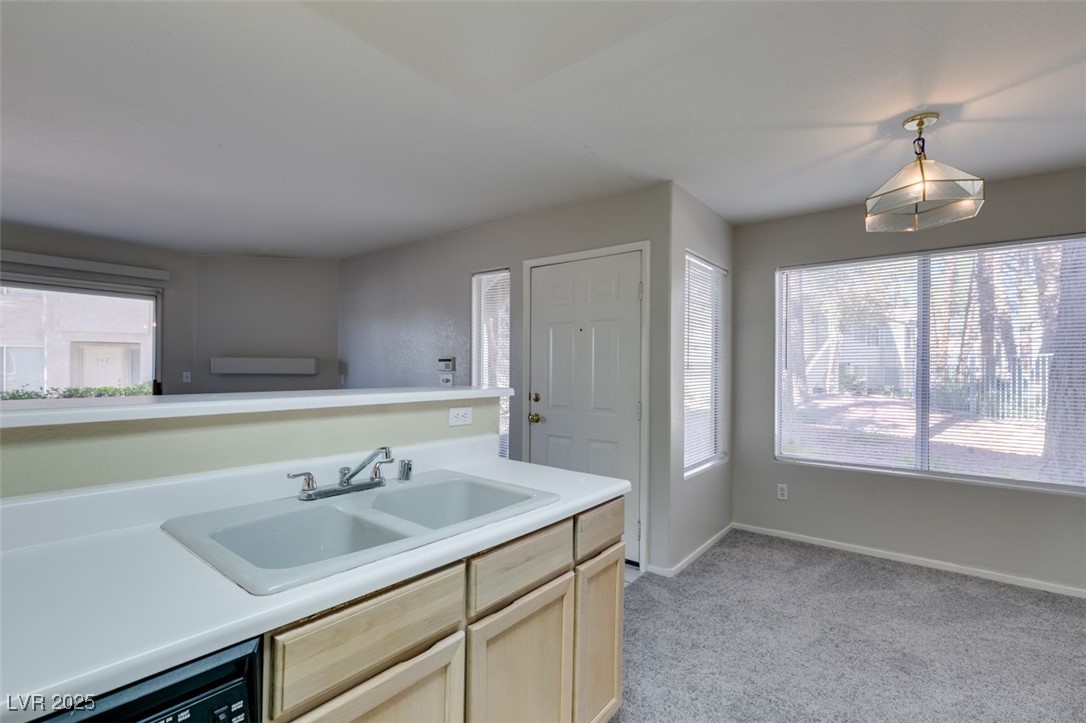 5211 Caspian Springs Drive, Unit 101 Las Vegas, NV 89120 - Photo 27 of 37 Kitchen featuring light brown cabinets, light countertops, light carpet, and dishwasher