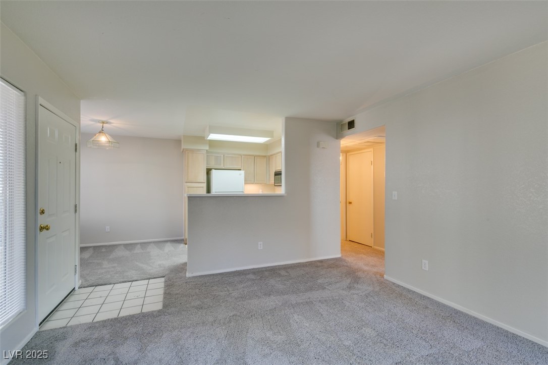 5211 Caspian Springs Drive, Unit 101 Las Vegas, NV 89120 - Photo 9 of 37 Empty room featuring light carpet and baseboards