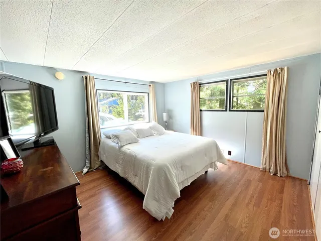 a bedroom with a bed and wooden floor