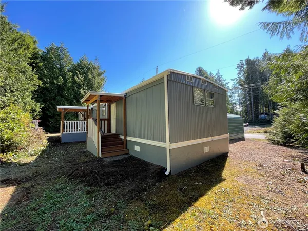 a view of a small house with a yard