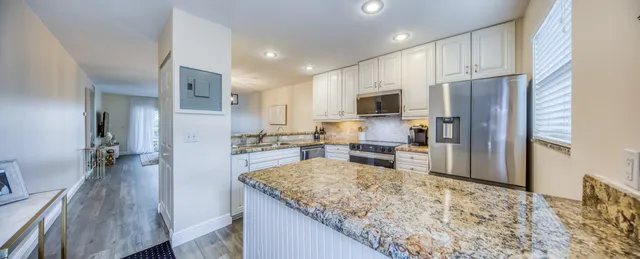 a living room with furniture and a large mirror next to a window