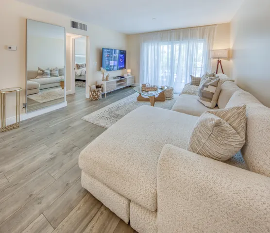 a living room with furniture and wooden floor