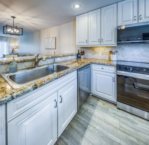 a kitchen with granite countertop a stainless steel appliances and cabinets
