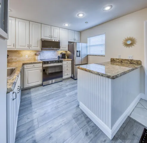 a kitchen with granite countertop a sink and cabinets