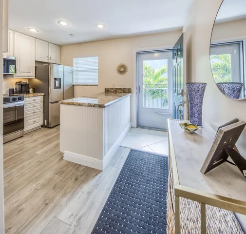 a large kitchen with granite countertop a sink and a stove top oven