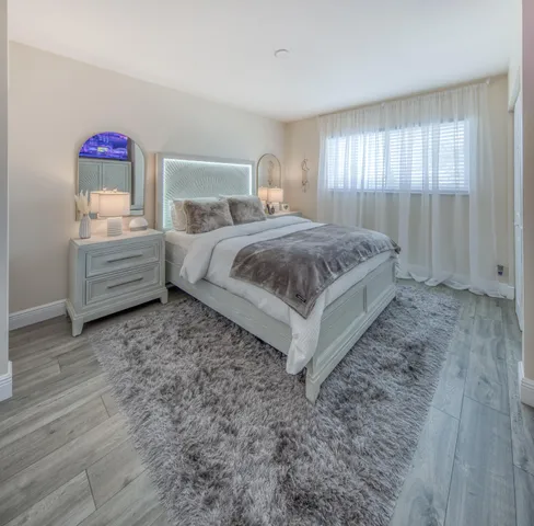 a spacious bedroom with a bed and wooden floor