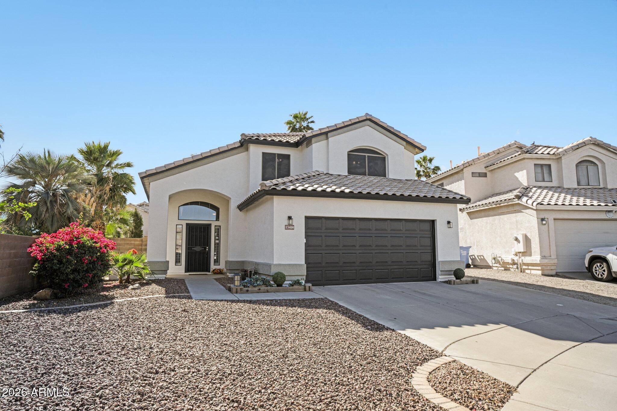 13414 South 47th Way Phoenix, AZ 85044 - Photo 2 of 32 a front view of a house with a garden