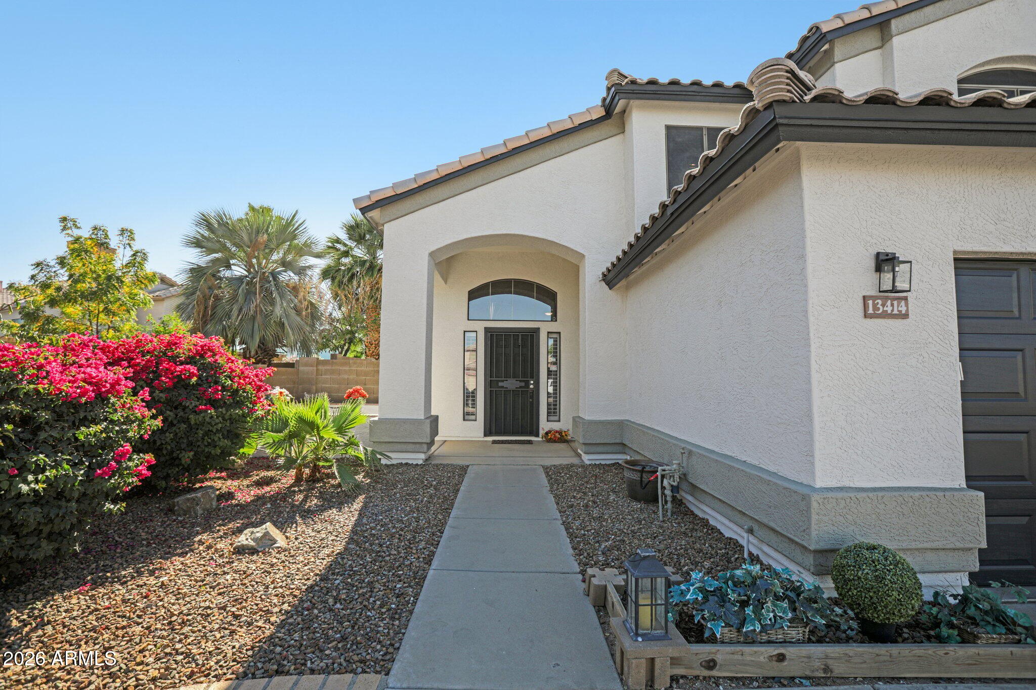 13414 South 47th Way Phoenix, AZ 85044 - Photo 3 of 32 a front view of a house with a garden
