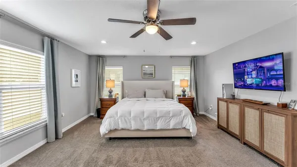 a spacious bedroom with a bed and a flat screen tv