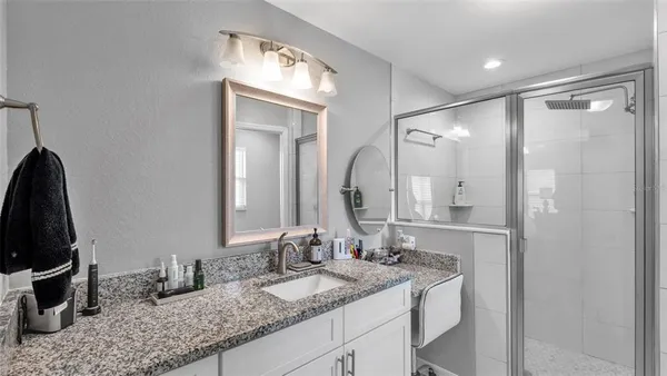 a bathroom with a granite countertop sink and a mirror