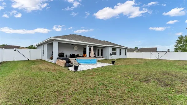 a view of a house with a patio and a yard