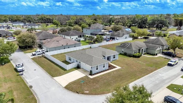 an aerial view of a house with a swimming pool and trees