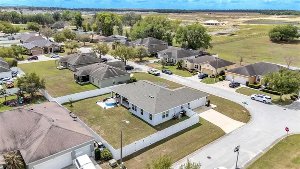 a view of a pool with lawn chairs and plants
