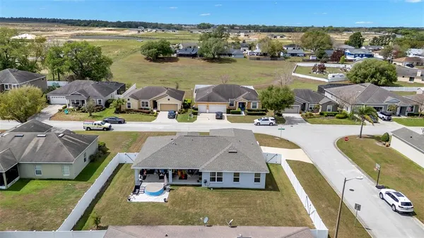 an aerial view of residential houses with outdoor space and lake view