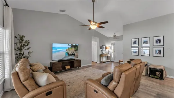 a living room with furniture a flat screen tv and a fireplace