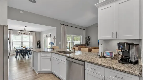 a kitchen with white cabinets and sink