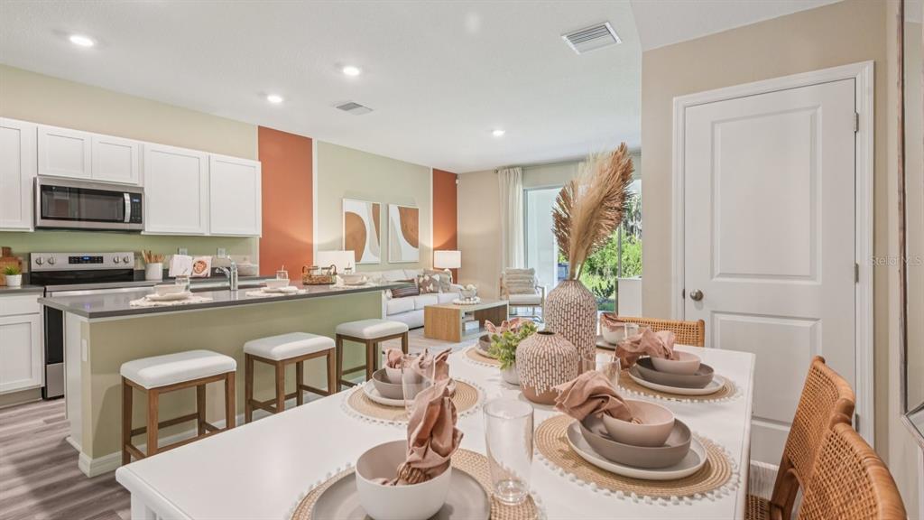 32463 Welling Blade Loop Wesley Chapel, FL 33545 - Photo 11 of 42 a kitchen with a dining table and chairs