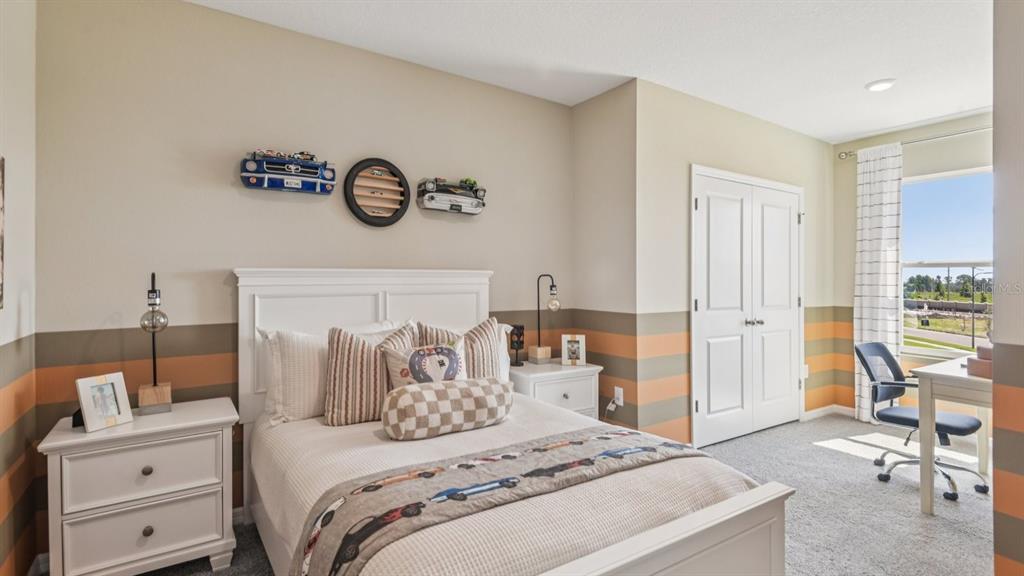 32463 Welling Blade Loop Wesley Chapel, FL 33545 - Photo 29 of 42 a bedroom with a bed and a table