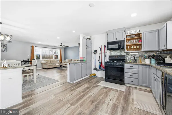 a kitchen with stainless steel appliances kitchen island wooden cabinets and granite counter tops
