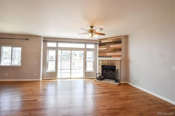 wooden floor fireplace and windows in an empty room