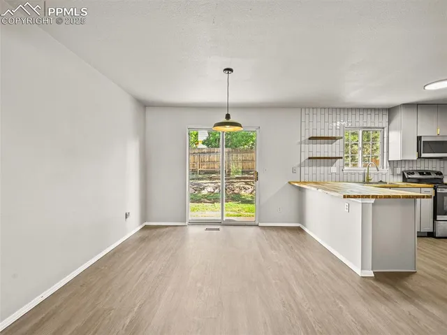 a kitchen with wooden floors and white walls