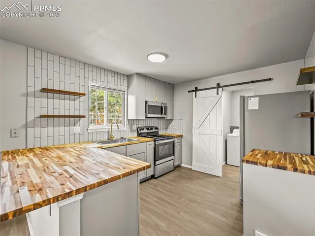 a kitchen with granite countertop a stove and a wooden floors