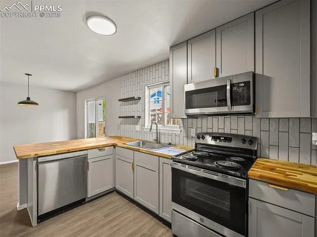 a kitchen with granite countertop cabinets stainless steel appliances and a sink