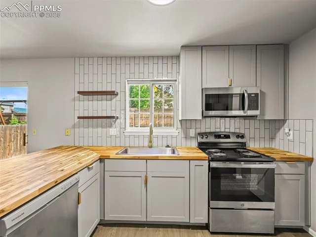 a kitchen with stainless steel appliances a stove a sink and a microwave