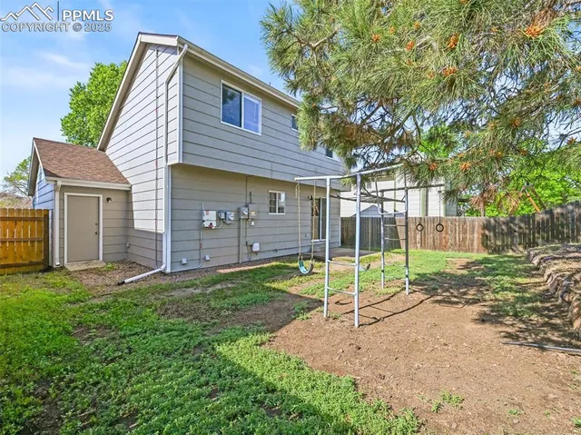 a view of a house with backyard and a tree