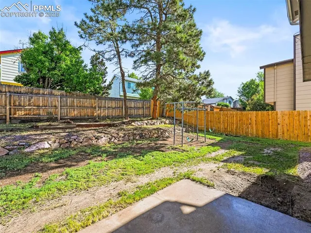 a view of a backyard with wooden fence
